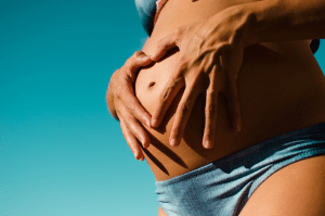 A pregnant woman about to get massage therapy in Minneapolis