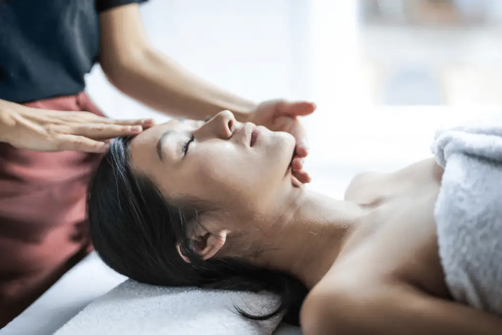 A person getting a scalp massage at a massage spa