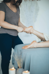 A massage therapist giving a foot massage.