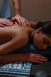 A woman with her eyes closed while receiving a massage