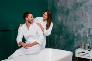 Two people wearing bathrobes getting a couples massage to reconnect.