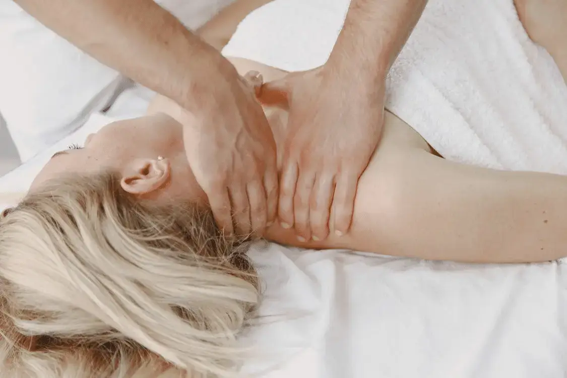woman wearing a towel getting a neck massage to release tension