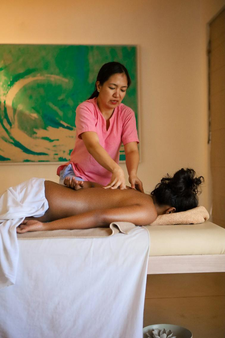 Massage therapist working on a client’s back to ease muscle stiffness.